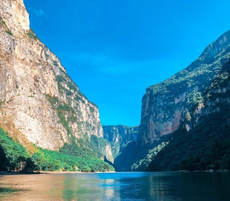 view from the river that cuts through the giant rock walls of the Sumidero Canyon, one of the most unique places to visit in mexico