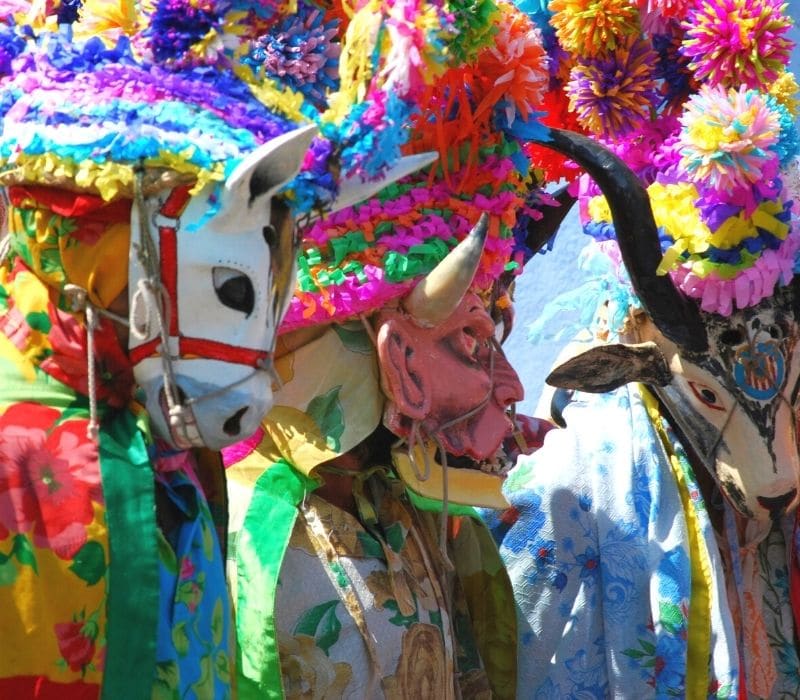 people wearing colorful masks at a parade in xico, veracruz mexico pueblos magicos