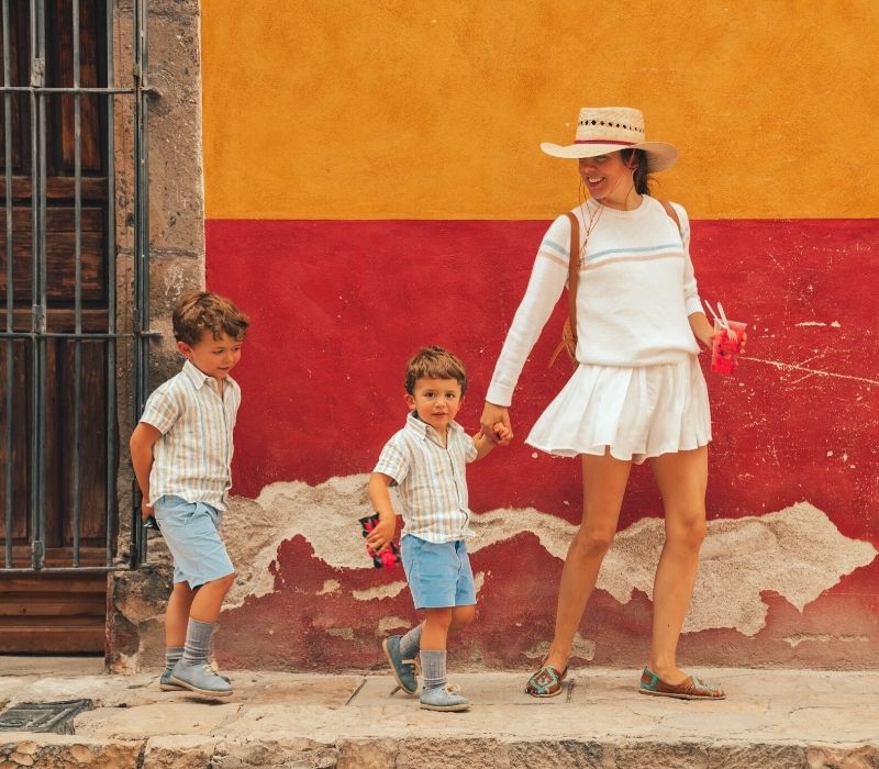 a woman wearing all white with two young boys walking in san miguel de allende, mexico | Mexican Traditions and Festive Mexico Holidays