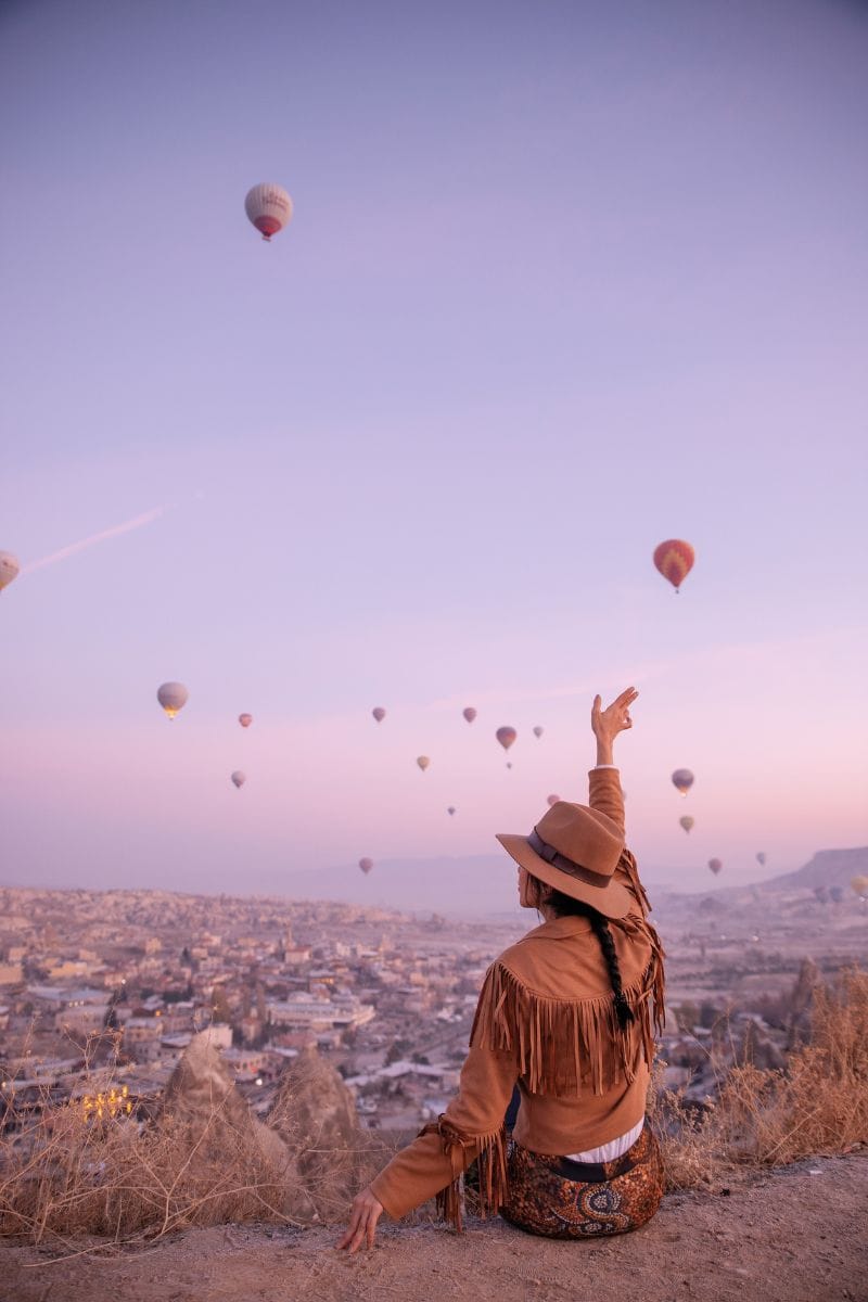 a woman watching air balloons from the heights