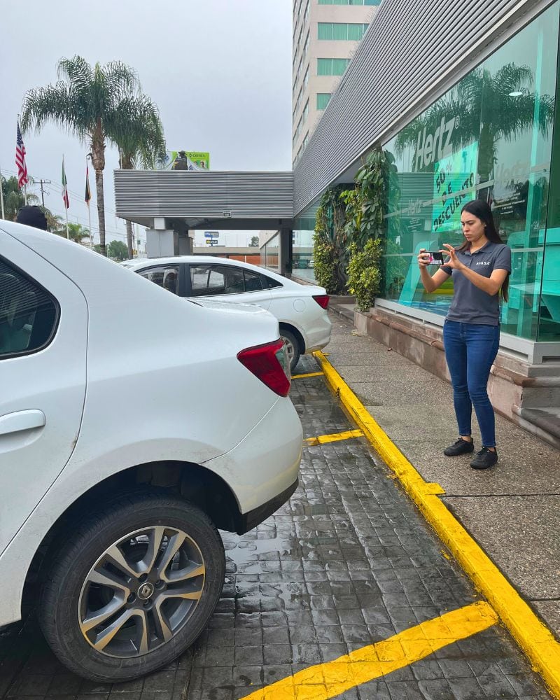 woman taking photos of a renal car in san luis potosi mexico