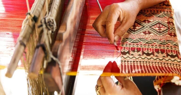person weaving on a loom in one of the best oaxaca art towns in mexico