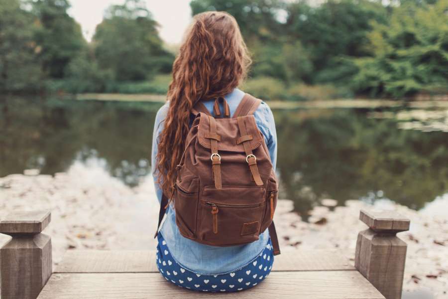 woman carrying a brown leather bag