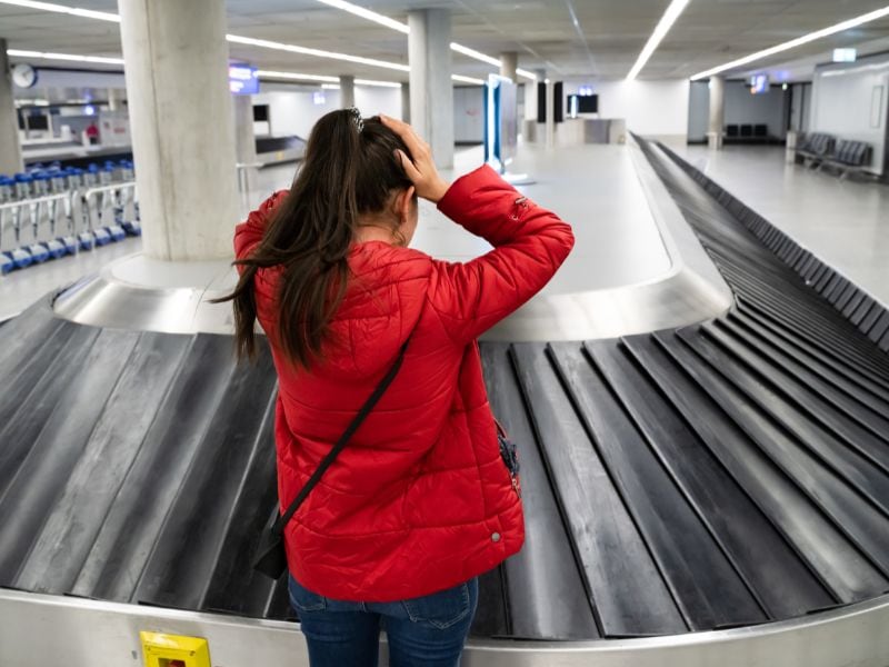 woman at luggage carousel in the airport but her luggage isn't there