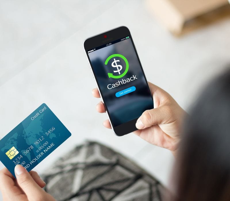 man holding a credit on one hand and a phone on the other