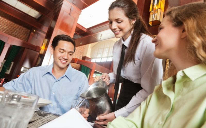 waitress refilling water for customers