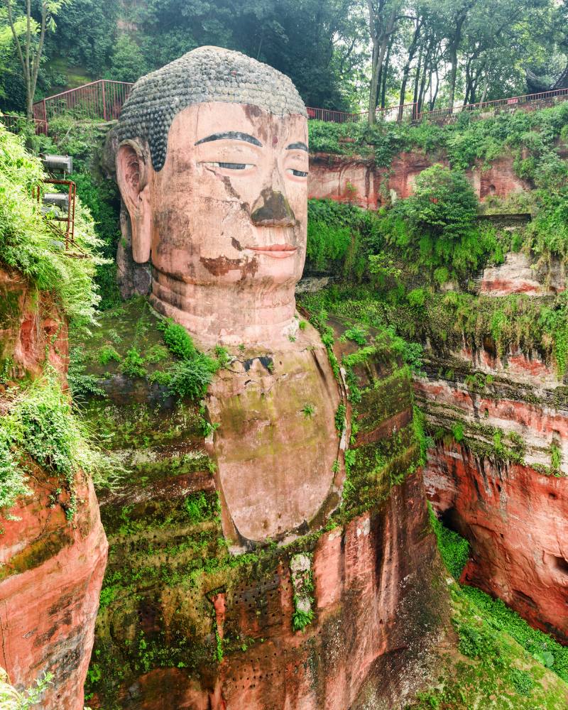 Leshan Giant Buddha mountain carving surrounded by greenery