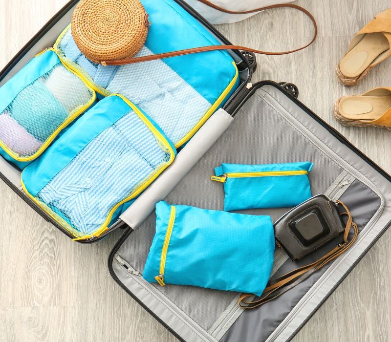 blue packing cubes inside an open luggage