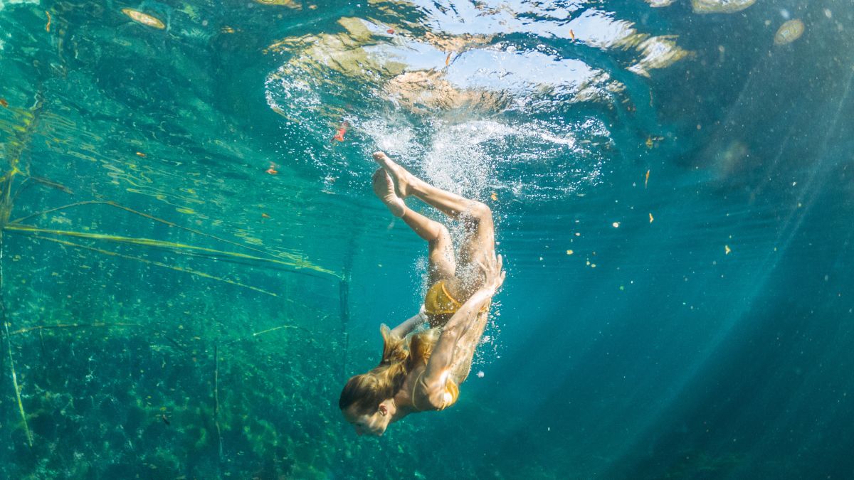 Underwater shot of woman diving in Mexican cenote