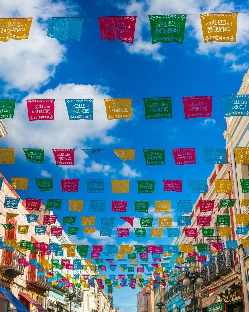 traditional mexican papel picado hanging above the street