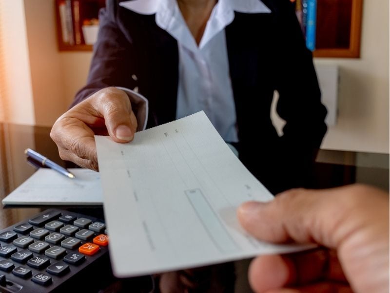 banker handing over a check to a customer