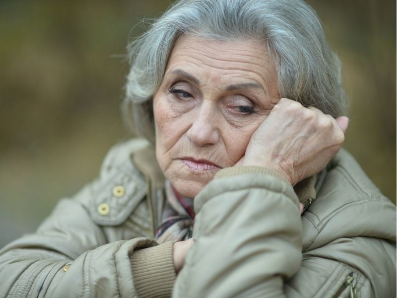 older woman with grey hair, looking sad or concerned