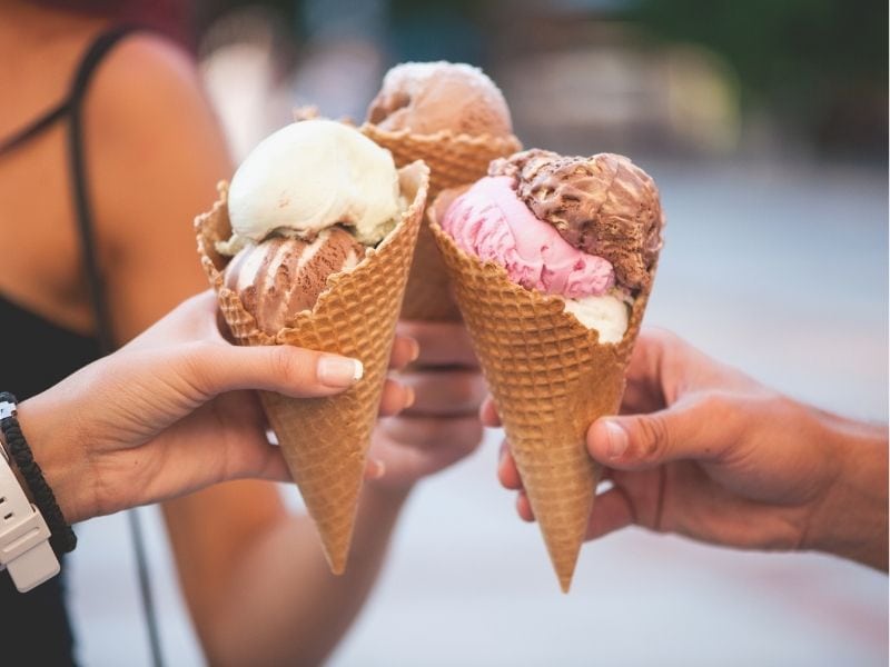 three women doing a "cheers" with ice cream cones