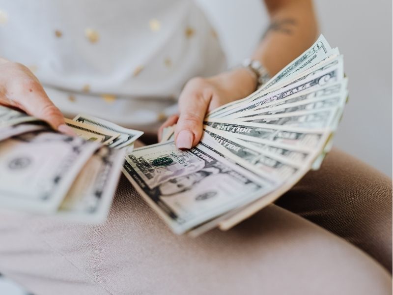 someone holding a bunch of dollars