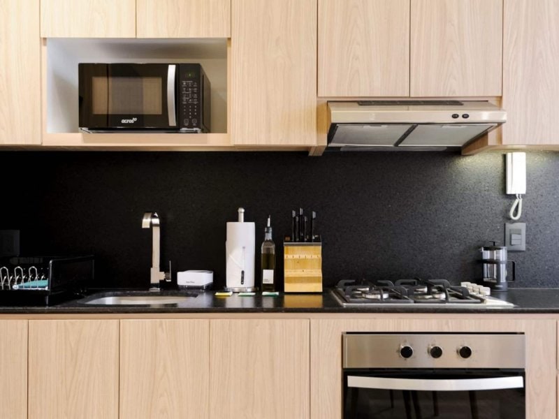 Modern kitchen with wood cabinets at the 2-Bedroom Apartment with a Terrace in Santa María la Ribera, a cheap Airbnb in Mexico City