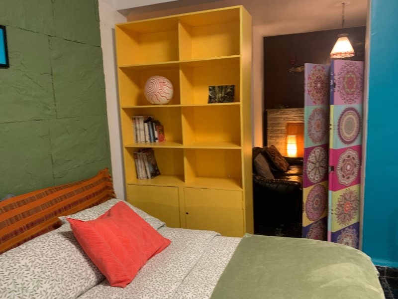 Colorful bedroom with a yellow bookcase at the 2-Bedroom Garden Home in Coyoacán, Mexico City