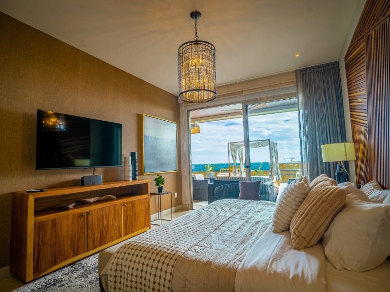 Bedroom with a sliding glass wall to the ocean-view terrace at the 3-Bedroom Condo with Arch Views in El Tezal, Cabo San Lucas