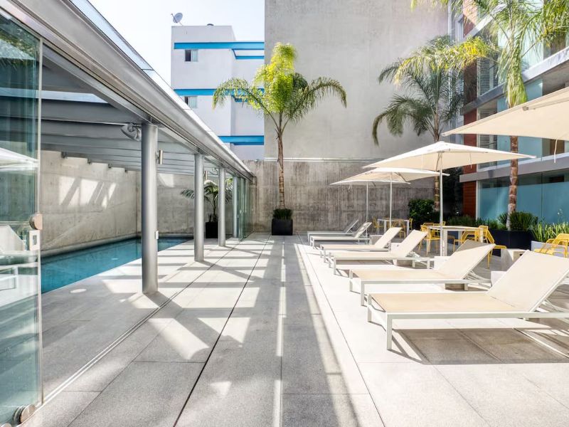 Indoor pool with lounge chairs at the Antara Miyana apartment Airbnb in Polanco, Mexico City