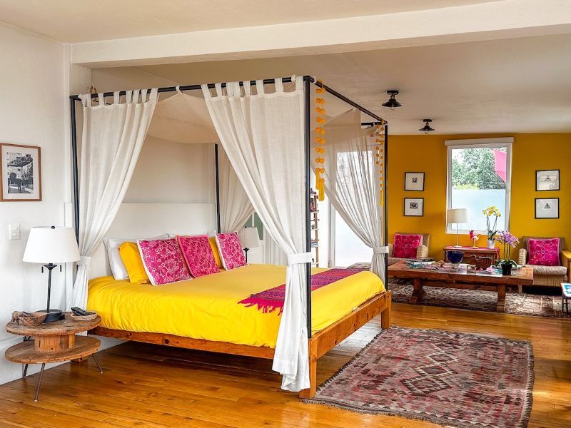 Canopy bed and colorful living space at the bright loft Airbnb in Escandón, Mexico City