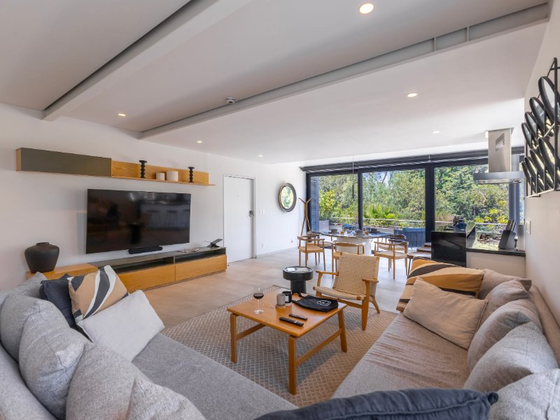 Bright living room with a sectional sofa and park views at the Capitalia Apartment with a Sunset Terrace in Polanco, a Mexico City luxury rental