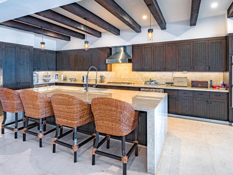 Chef's kitchen with a long island and bar stools at Casa Alvar in Quivira, Cabo San Lucas