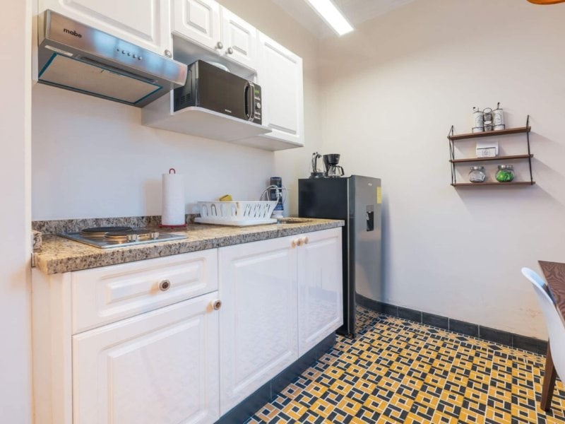 White kitchen with patterned floor tiles at the Casa Boris 1-bedroom in Cuauhtémoc, Mexico City