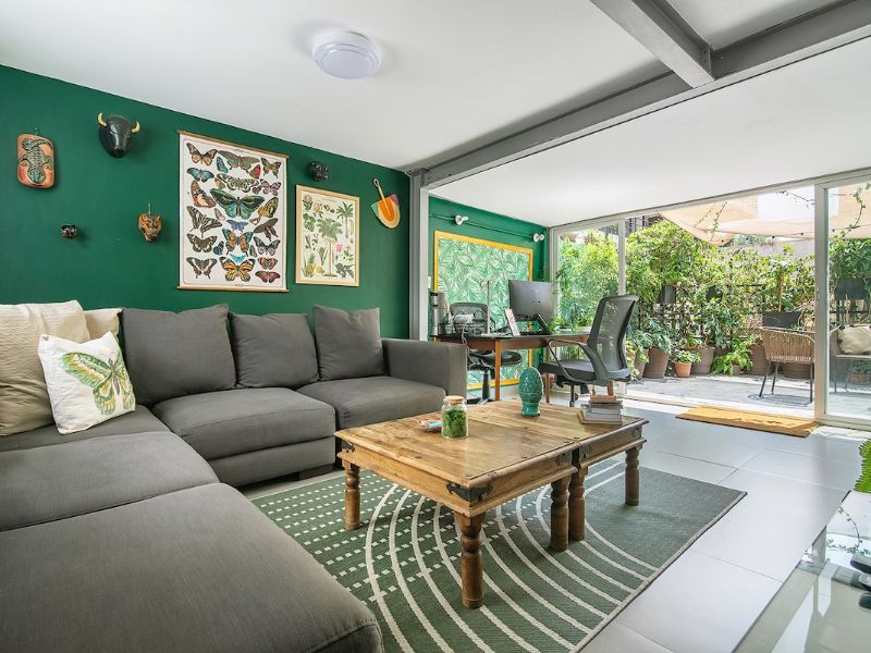 Green living room with plants at Casa Chaya Airbnb in Roma Norte, Mexico City