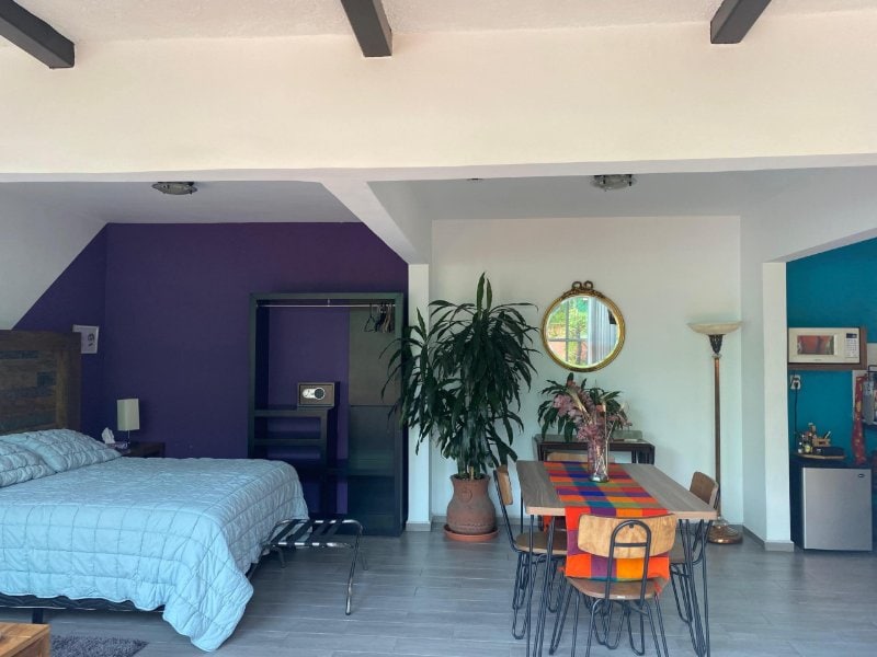 Purple-walled bedroom and dining area at the Casa de la Sierra Loft with a Terrace in Guadalupe Inn, Mexico City