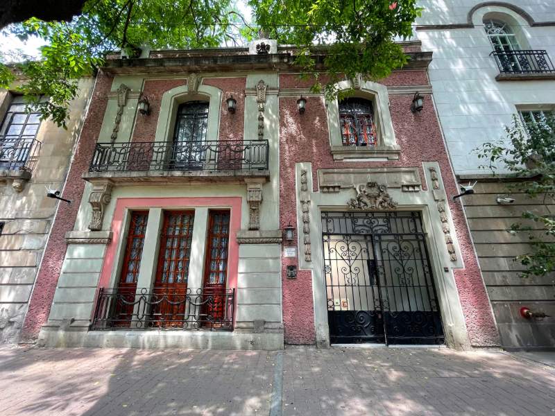 Historic pink facade with wrought-iron balconies at Casa de las Campanas in Roma Norte, Mexico City