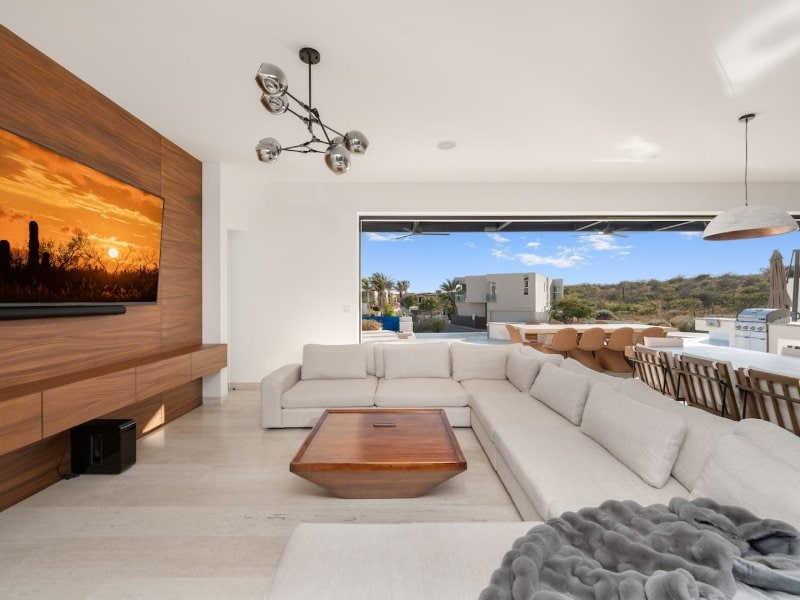 Living room with a wall of glass opening onto the terrace at Casa La Chula in Pedregal, Cabo San Lucas