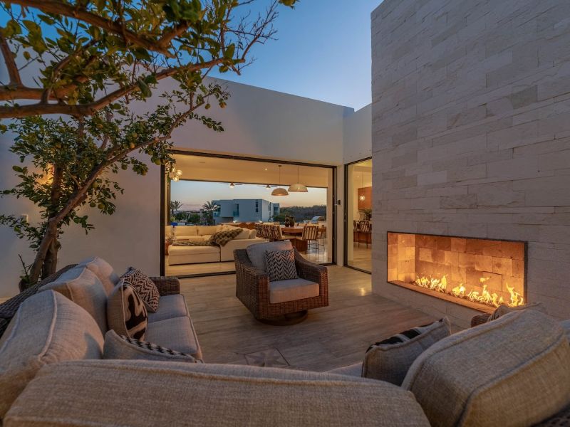 Outdoor lounge with a fireplace at dusk at Casa La Chula in Pedregal, Cabo San Lucas