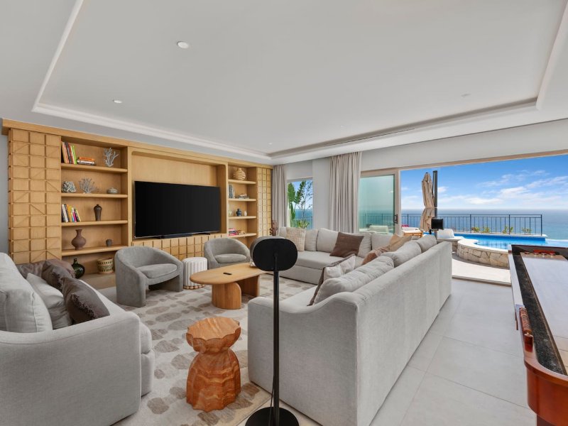 Living room opening onto the pool terrace with ocean views at Casa La Maraca in Pedregal, Cabo San Lucas