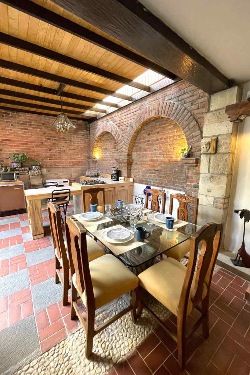 Dining table under a wooden pergola at the Coyoacán casita Airbnb with a private garden, Mexico City