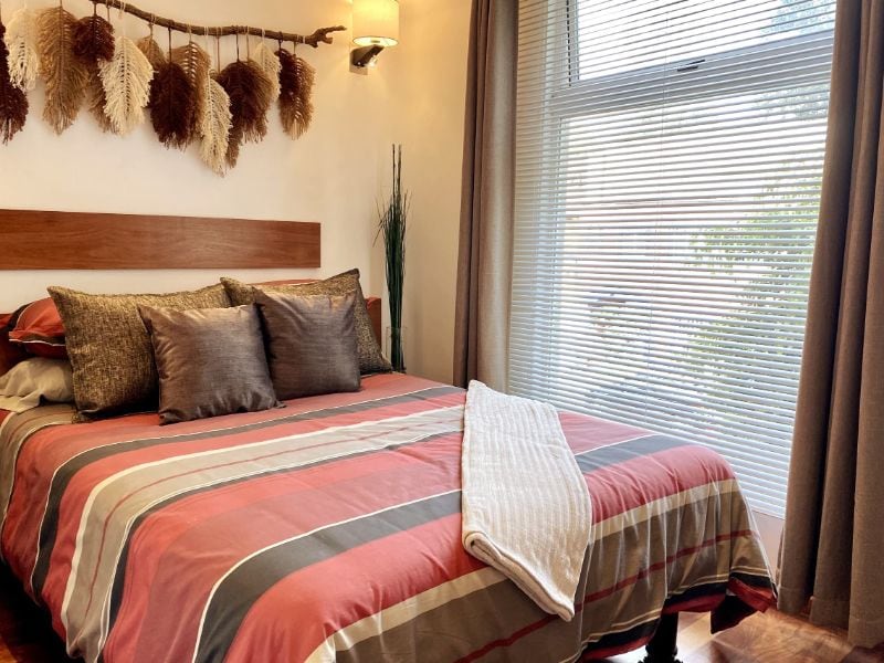 Bedroom with a striped bedspread at Diego Loft Airbnb in Coyoacán, Mexico City