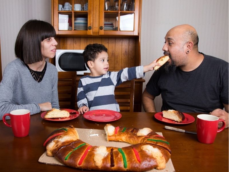 family eating rosca de reyes ring cake in mexico