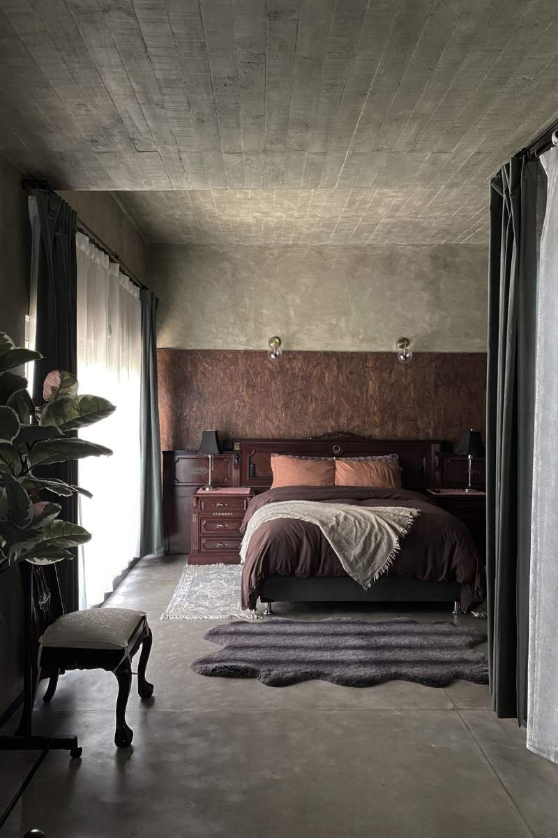 Bedroom with concrete walls at the Historic Fairytale Garden Loft Airbnb in Polanco, Mexico City