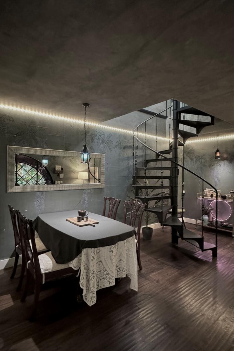 Dining table by a spiral staircase at the Historic Fairytale Garden Loft, a Mexico City Airbnb in Polanco