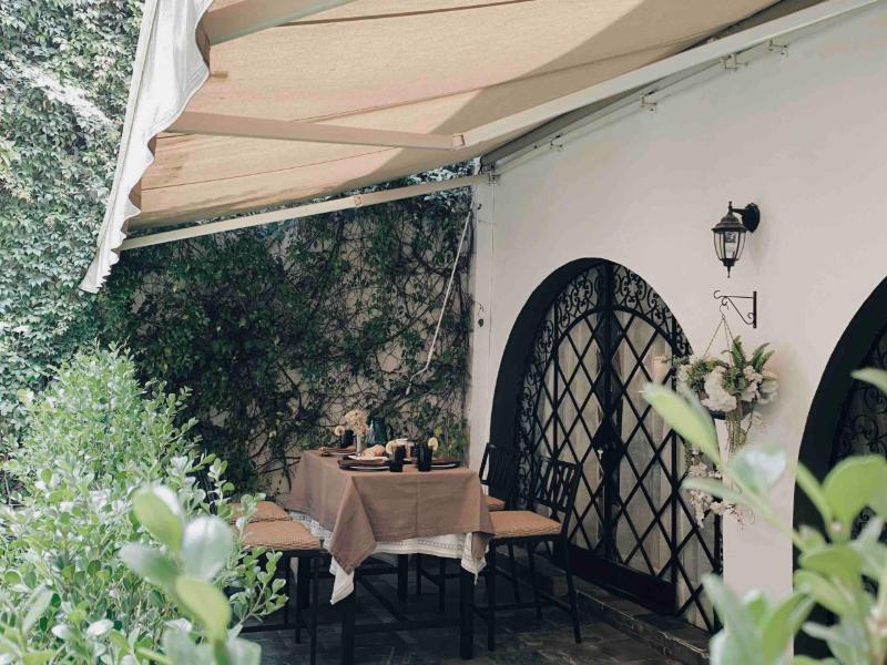 Garden patio with an arched iron door at the Historic Fairytale Garden Loft Airbnb in Polanco, Mexico City