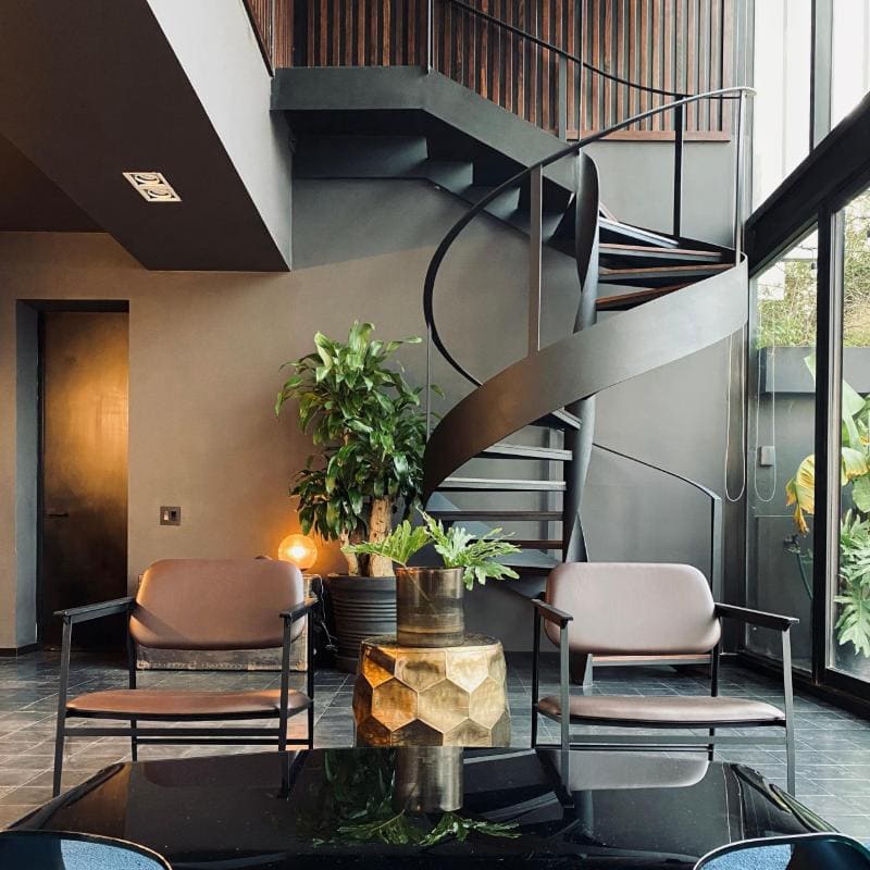 Spiral staircase and lounge chairs at the Lavish in Black Airbnb on Avenida Ámsterdam in Condesa, Mexico City