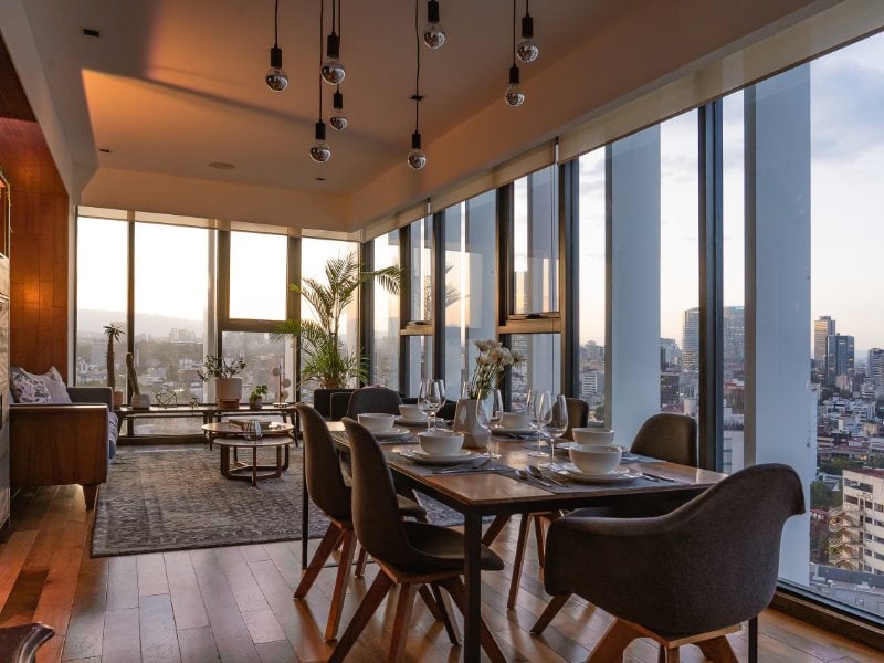 Dining room with floor-to-ceiling city views at the Luxury Condesa with the Best View in Town Airbnb, Mexico City