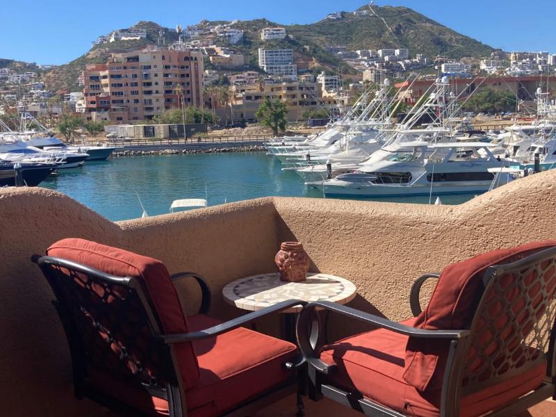 Balcony with red armchairs overlooking the yachts at the Marina Cabo Plaza Studio in Cabo San Lucas