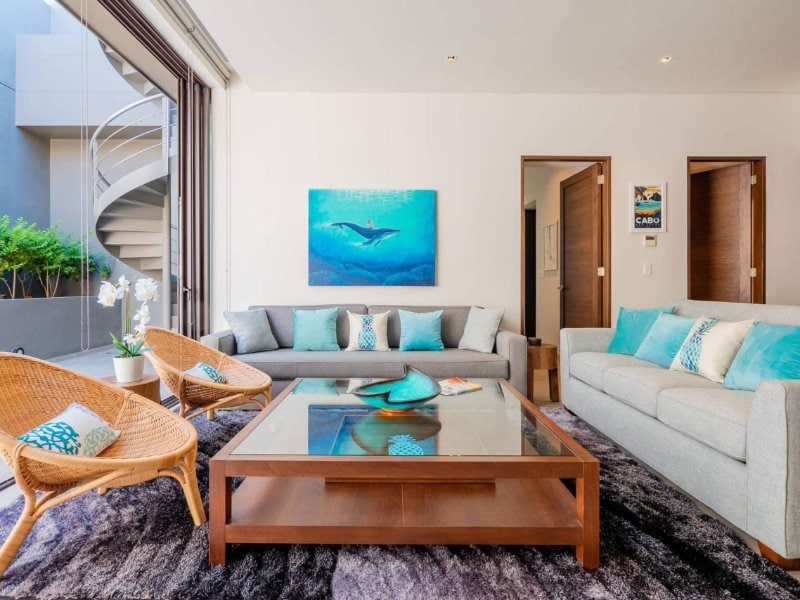 Bright living room with white sofas at the Marina Condo with a Private Rooftop Hot Tub in Cabo Marina, Cabo San Lucas