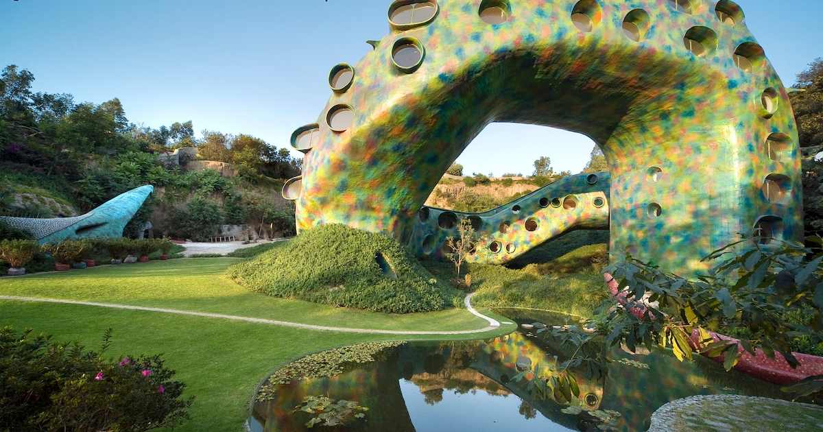 Mosaic-tiled body of the Mexico City snake house Airbnb arching over a pond
