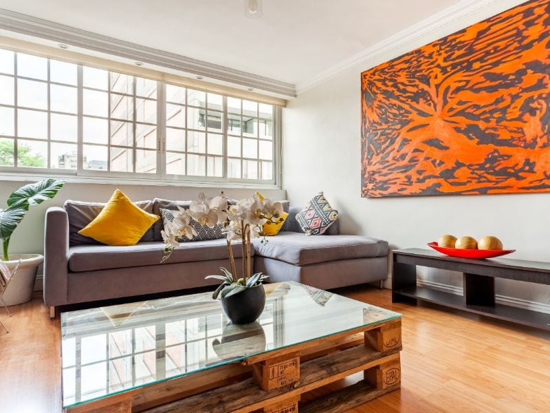 Living room with an orange artwork at the modern 1-bedroom Airbnb in Polanco, Mexico City