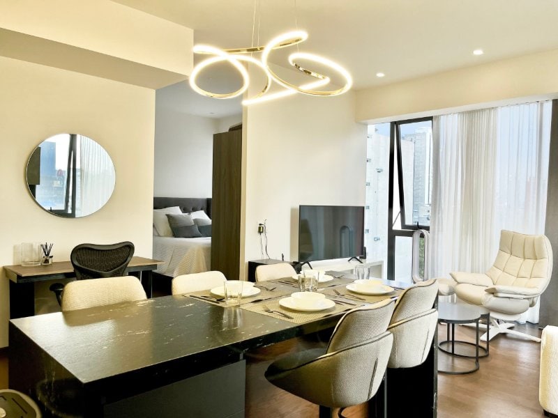 Dining area with a modern chandelier at the apartment Airbnb with a pool and gym in Polanco, Mexico City