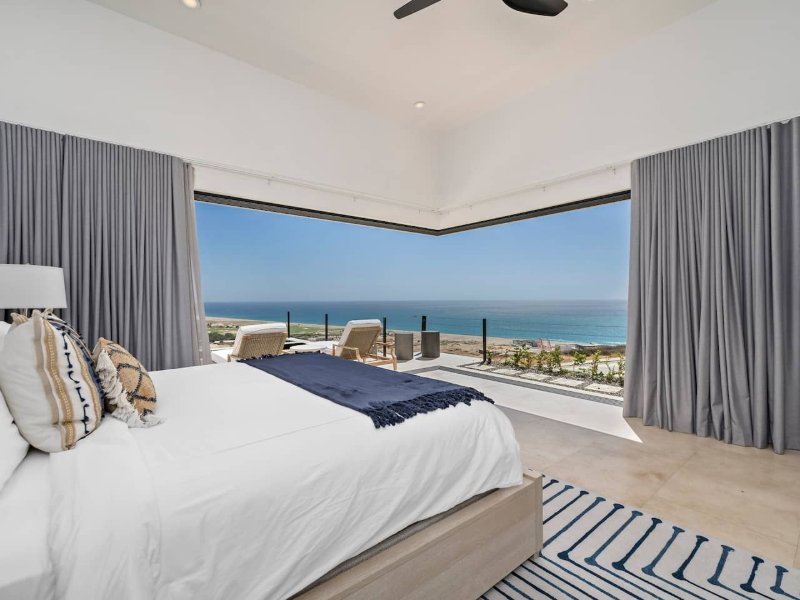 Bedroom with floor-to-ceiling ocean views at the Ocean-View Villa in Quivira, Cabo San Lucas