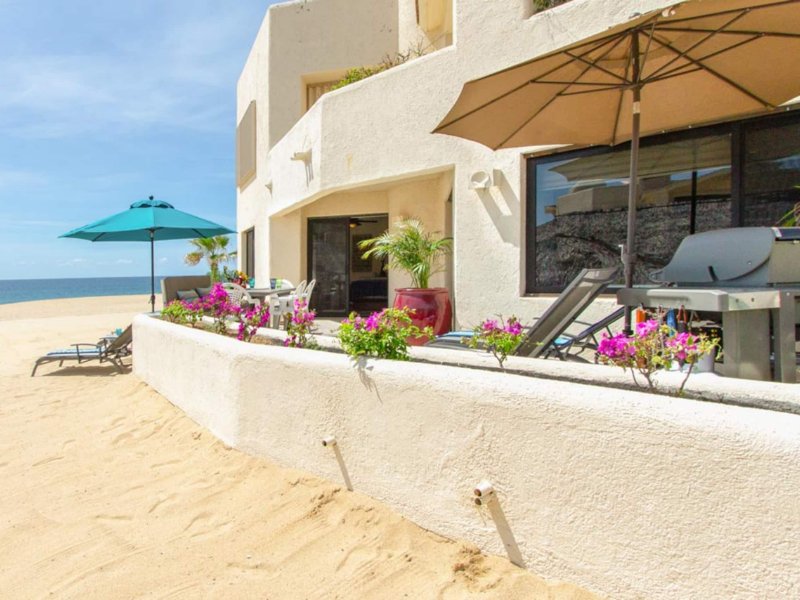 Beachfront patio steps from the sand at the Oceanfront Condo at Terrasol, a Cabo San Lucas Airbnb