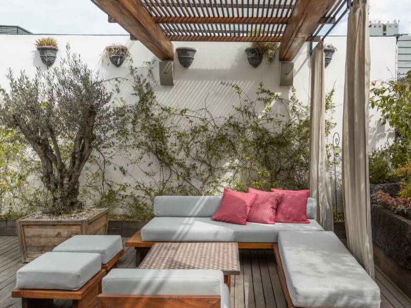 Rooftop terrace with a pergola and lounge seating at the Pianist 1900s House Airbnb in Roma Norte, Mexico City