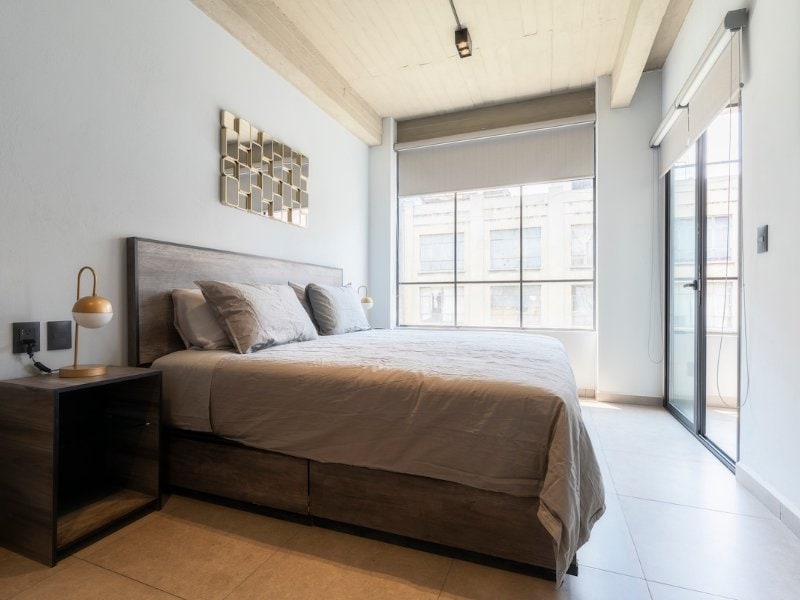Bedroom with tall windows at the 3-bedroom Airbnb near the Zócalo in Mexico City's Centro Histórico