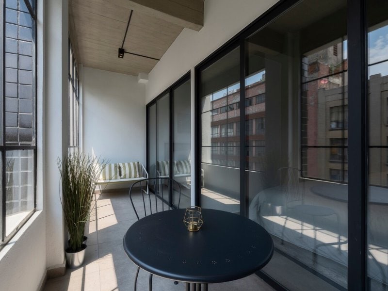 Glass-walled terrace with a bistro table at the 3-bedroom Airbnb near the Zócalo, Mexico City
